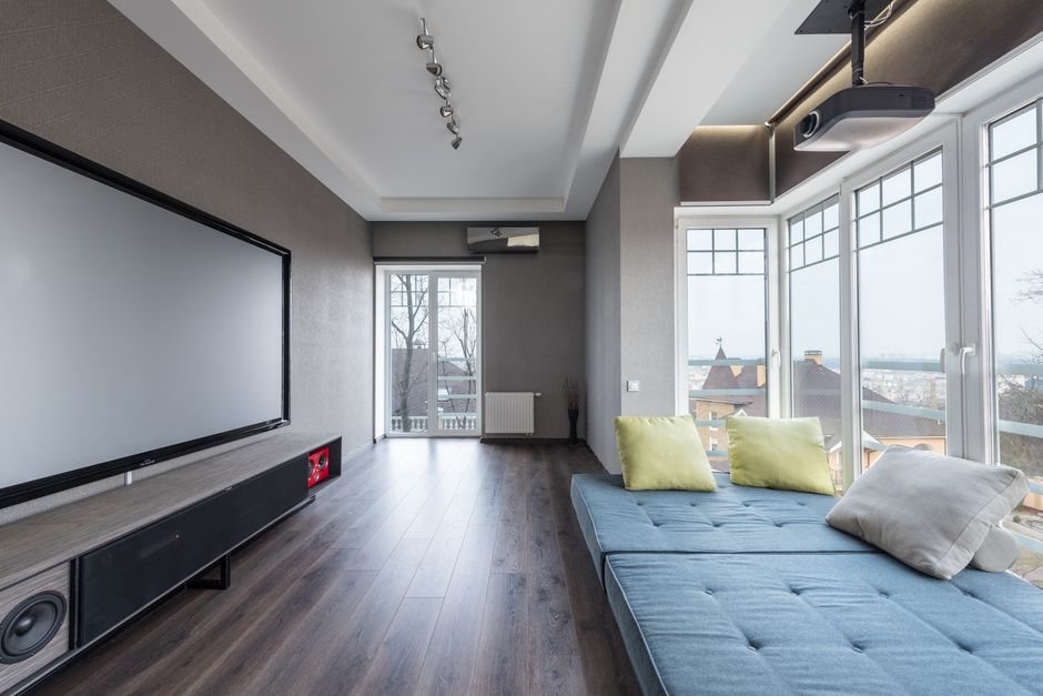 Stijlvolle cinewall met zwevende TV en moderne inrichting in een woonkamer.